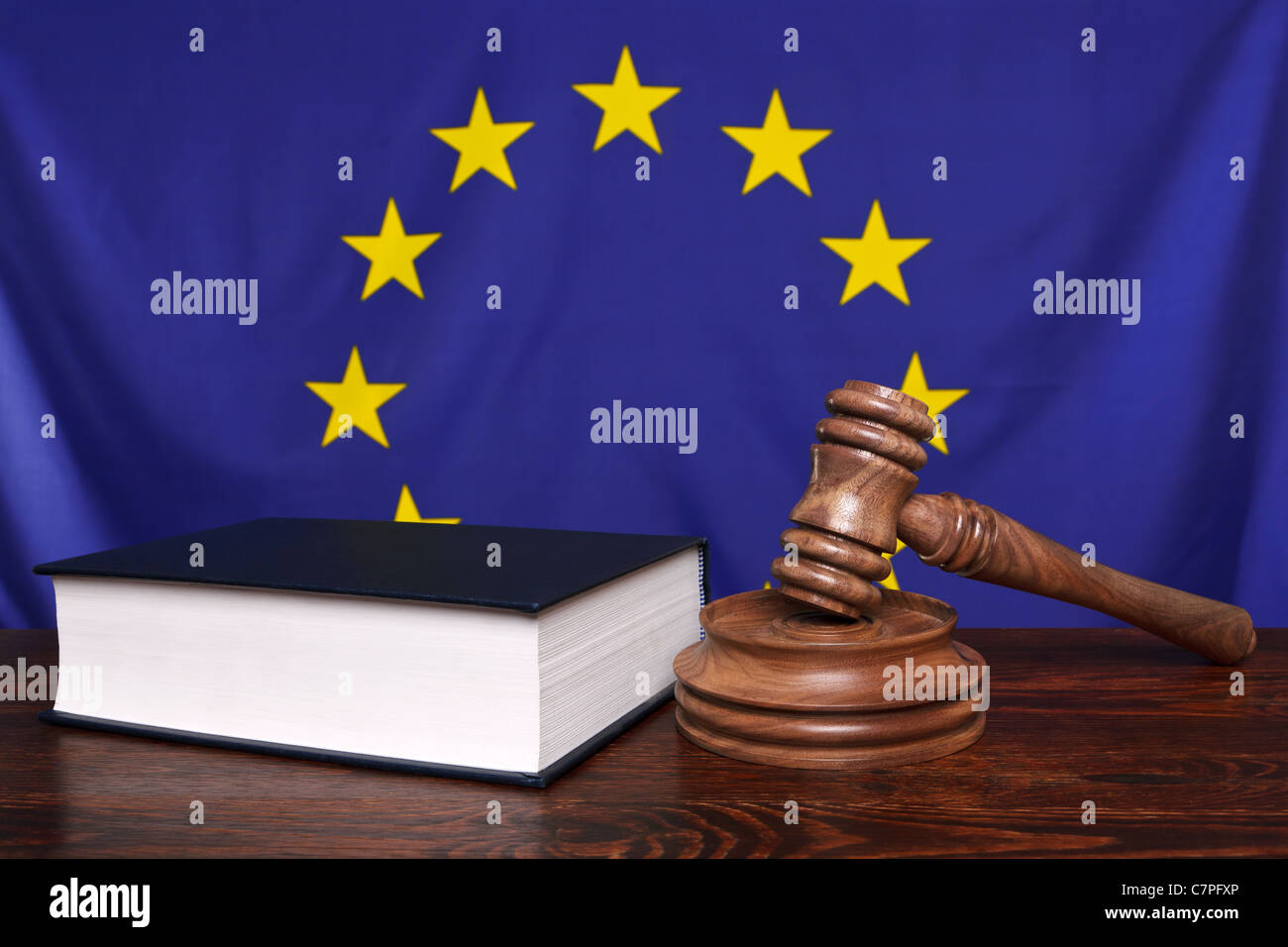Still-Leben Foto von einem Hammer, Block und Gesetz Buch auf einer Richter-Bank mit der Flagge der Europäischen Union hinter. Stockfoto