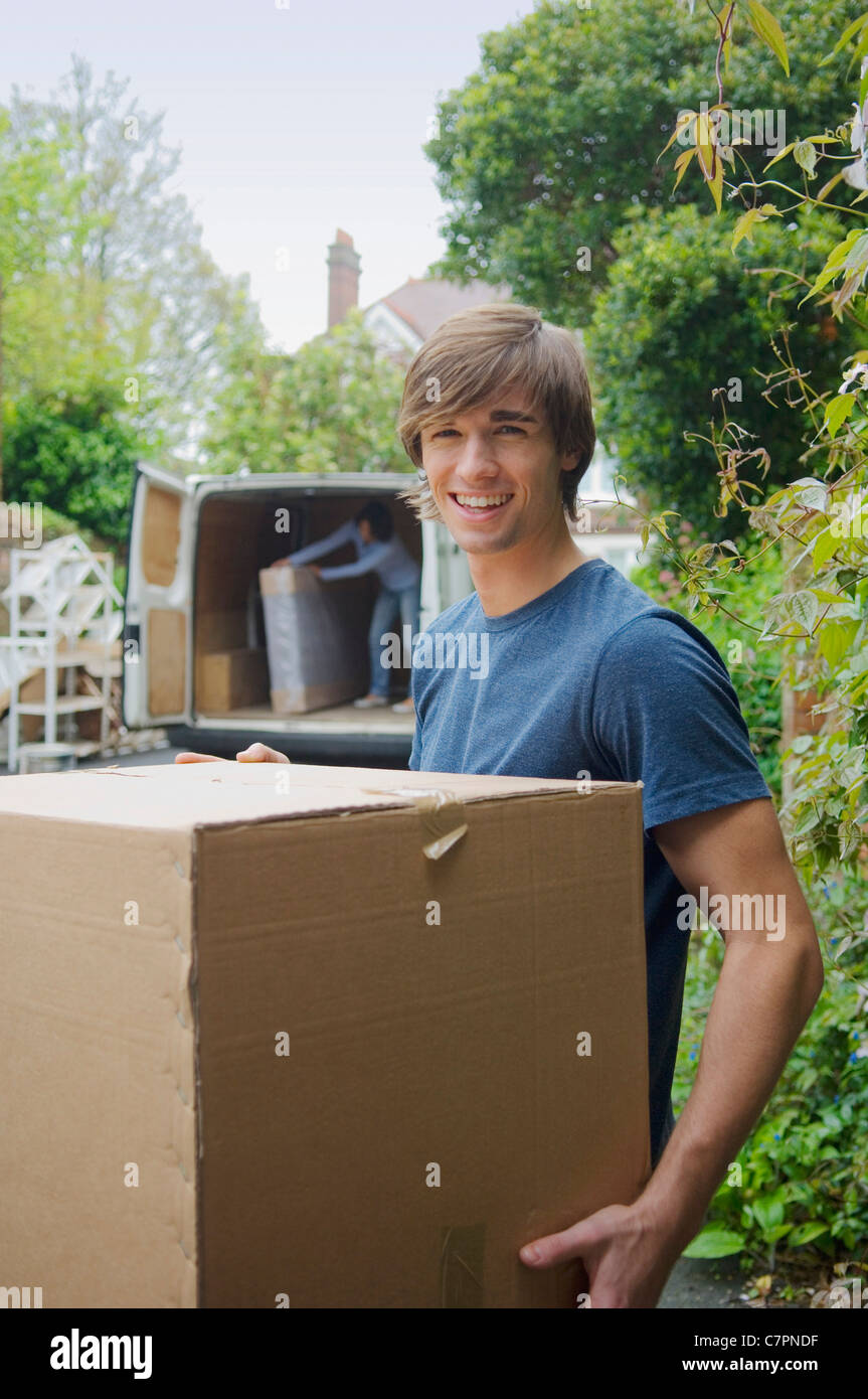 Mann mit Karton im neuen Zuhause Stockfoto