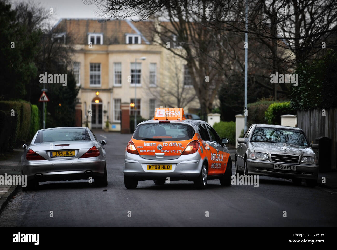 BSM Instruktoren Steuerwagen kehrt um eine stationäre Mercedes in einem in der Regel Vorort Straße in England UK Stockfoto