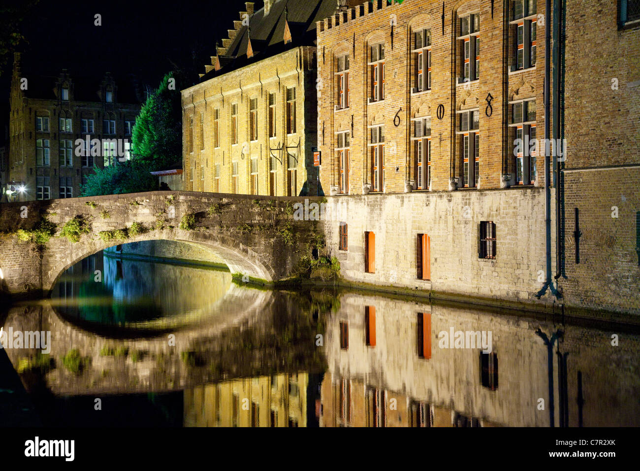 Kanal und Stone Bridge in Brügge, Belgien von Steenhouwers Dijk bei Nacht. Stockfoto