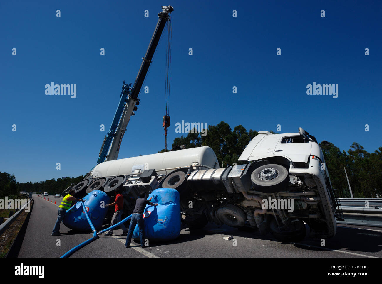 Menschen versuchen, ein umgestürzter Tankwagen mit Hilfe eines mobilen Krans Autos drehen Stockfoto