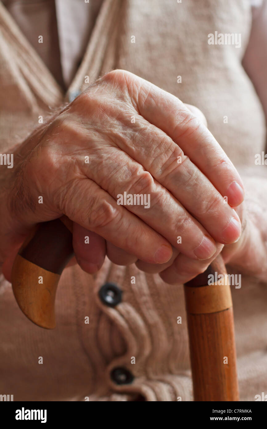Hände eines älteren Mannes hält einen Stock Stockfoto