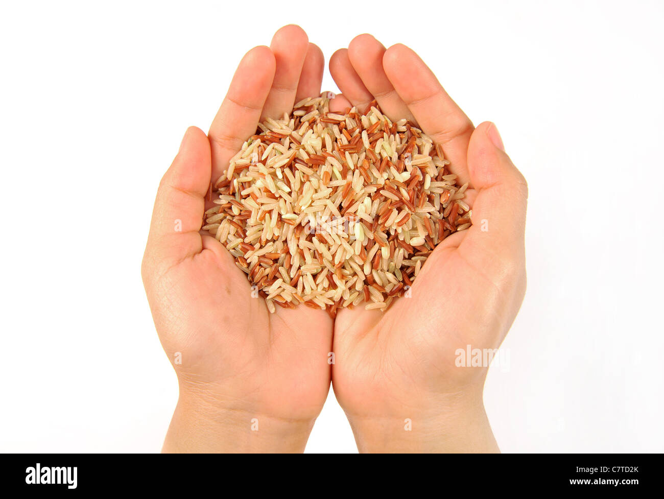 Brauner Reis in Frauenhand (isoliert auf weiss) Stockfoto