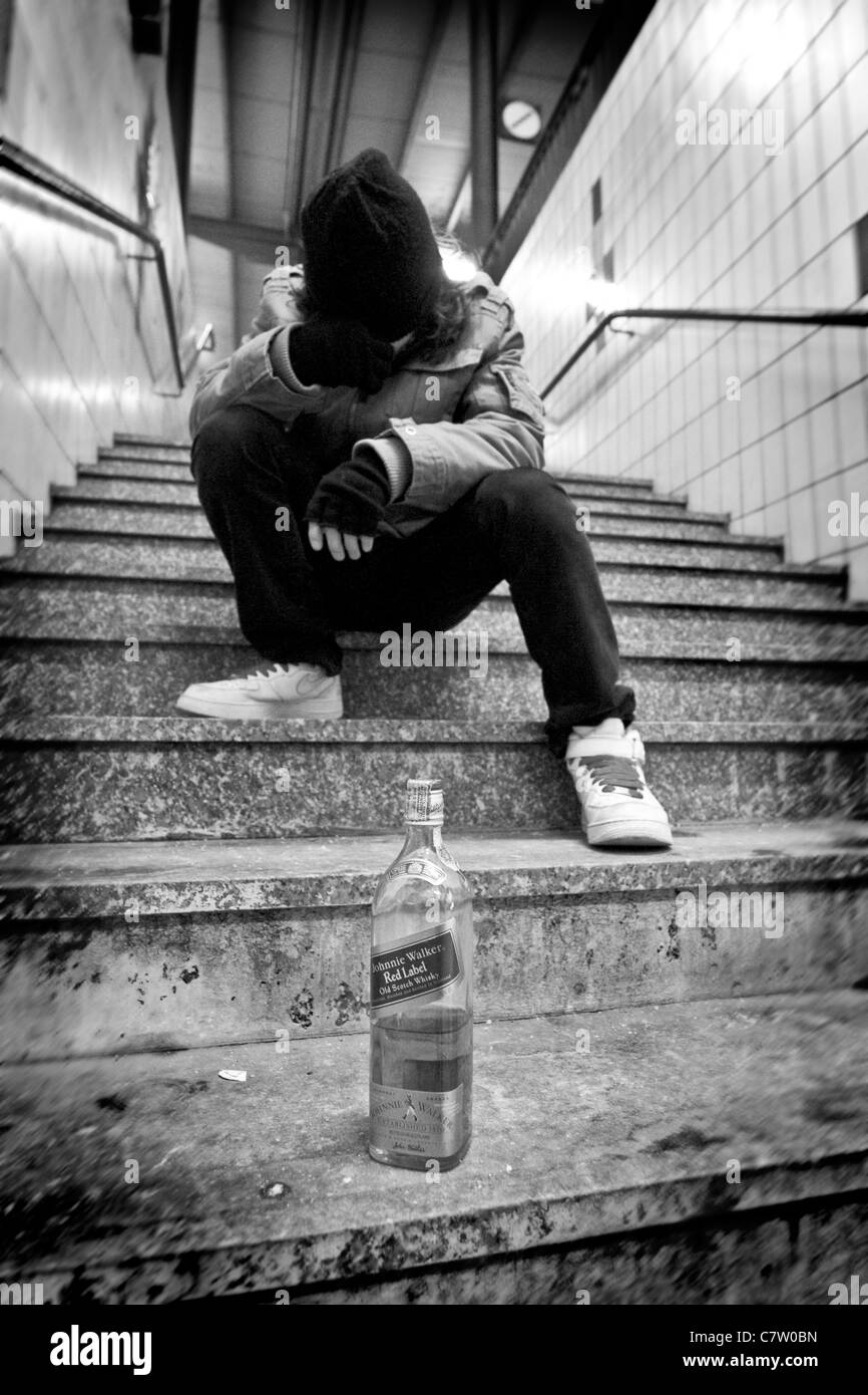 Betrunkene Junge sitzt im freien Stockfoto