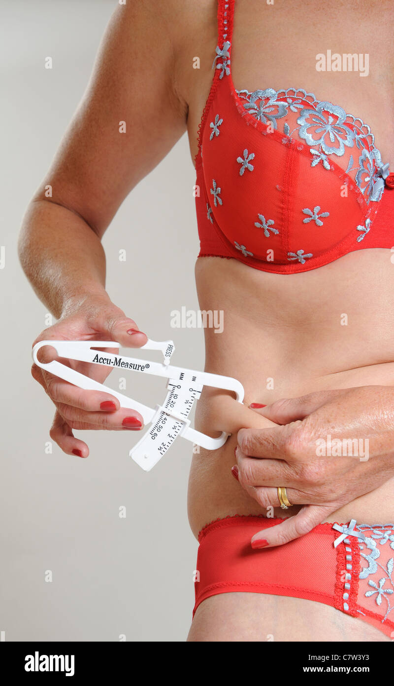 Mittleren Alters verteilt Frau Überprüfung ihrer Fettmessung Stockfoto