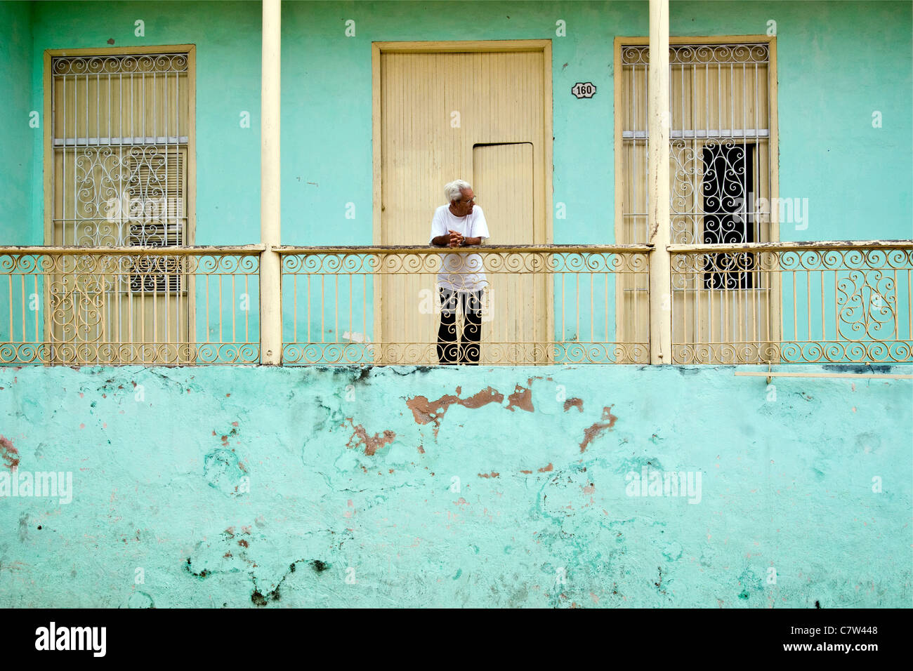 Kuba, Santiago, Mann steht auf Balkon Stockfoto