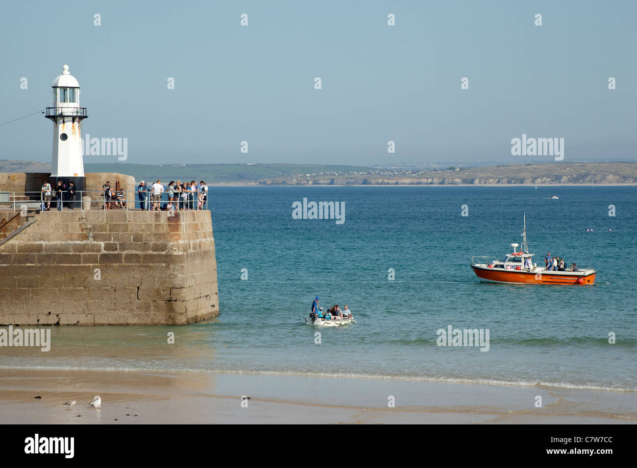 Ein kleines Boot, die Menschen bei Ebbe von St. Ives Pier, das Seepferdchen für eine Bootsfahrt. Stockfoto