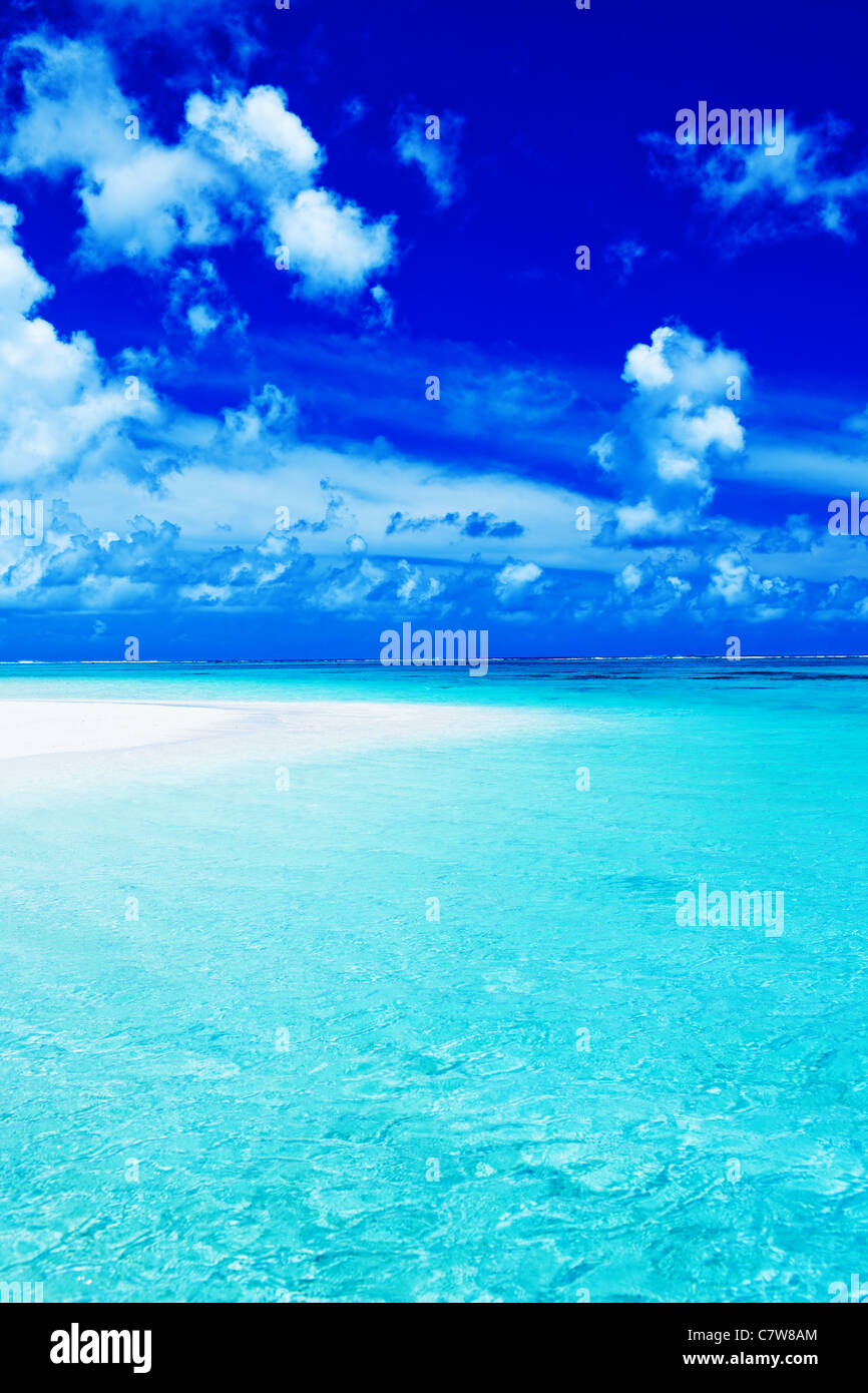 Leerer Strand mit blauem Himmel und lebendigen Ozean Farben Stockfoto
