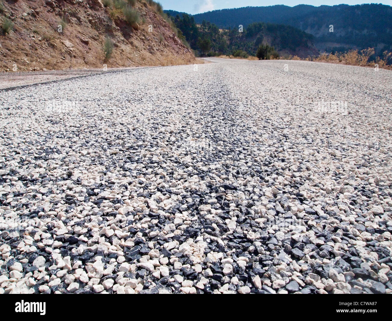 BILD EINER NAHAUFNAHME VON FRISCH VERLEGTEN GRANITSPLITTERN AUF ASPHALT AUF DER STRASSE IN DER TÜRKEI Stockfoto