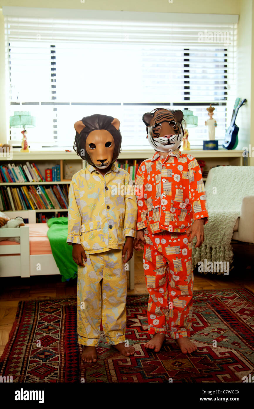 Zwei Kinder mit Masken auf im Pyjama Stockfoto