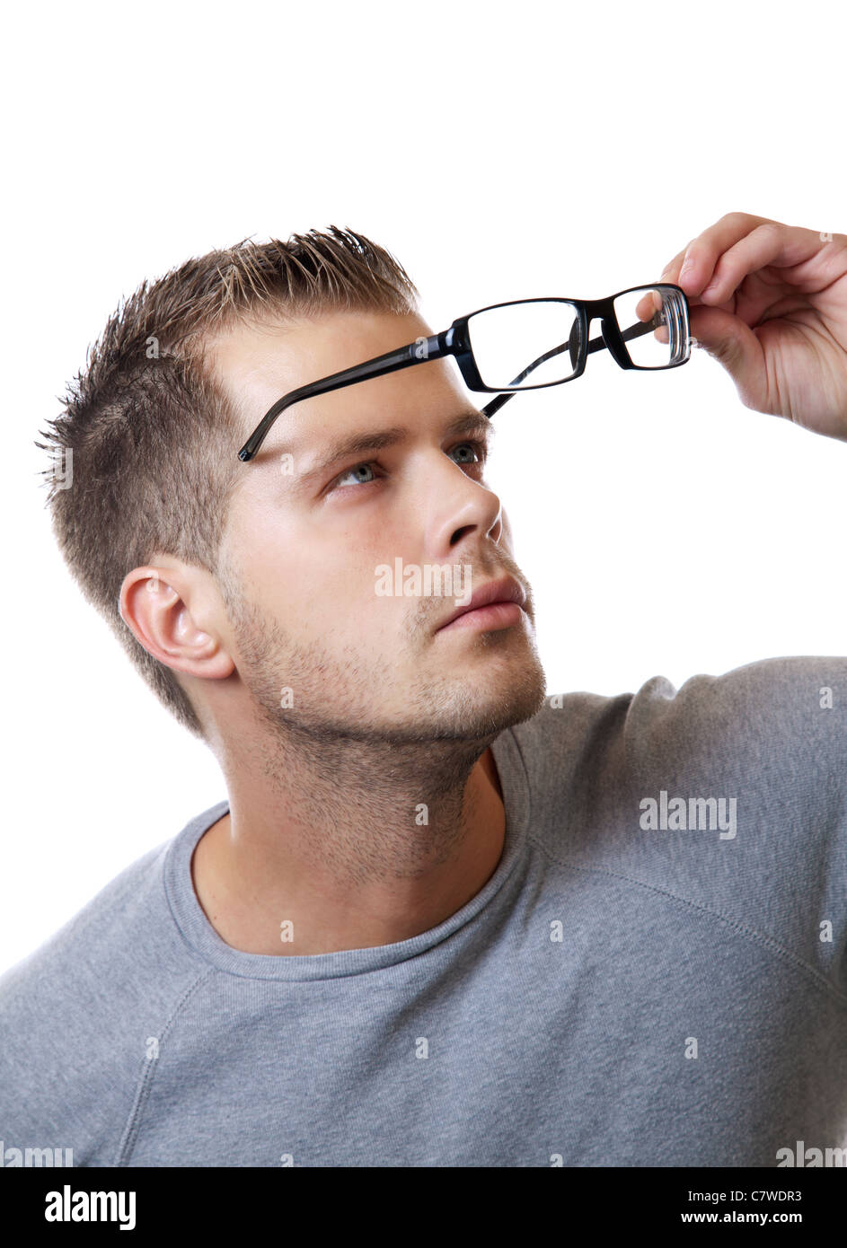 Junger Mann setzt seine Brille auf Stockfoto