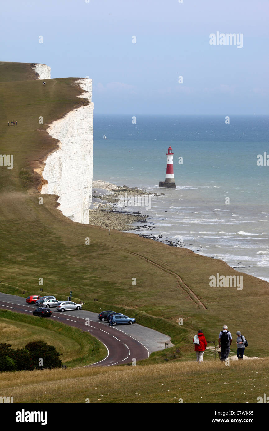 Menschen zu Fuß entlang der Küstenweg, Beachy Head Leuchtturm im Hintergrund, in der Nähe von Eastbourne, East Sussex, England Stockfoto