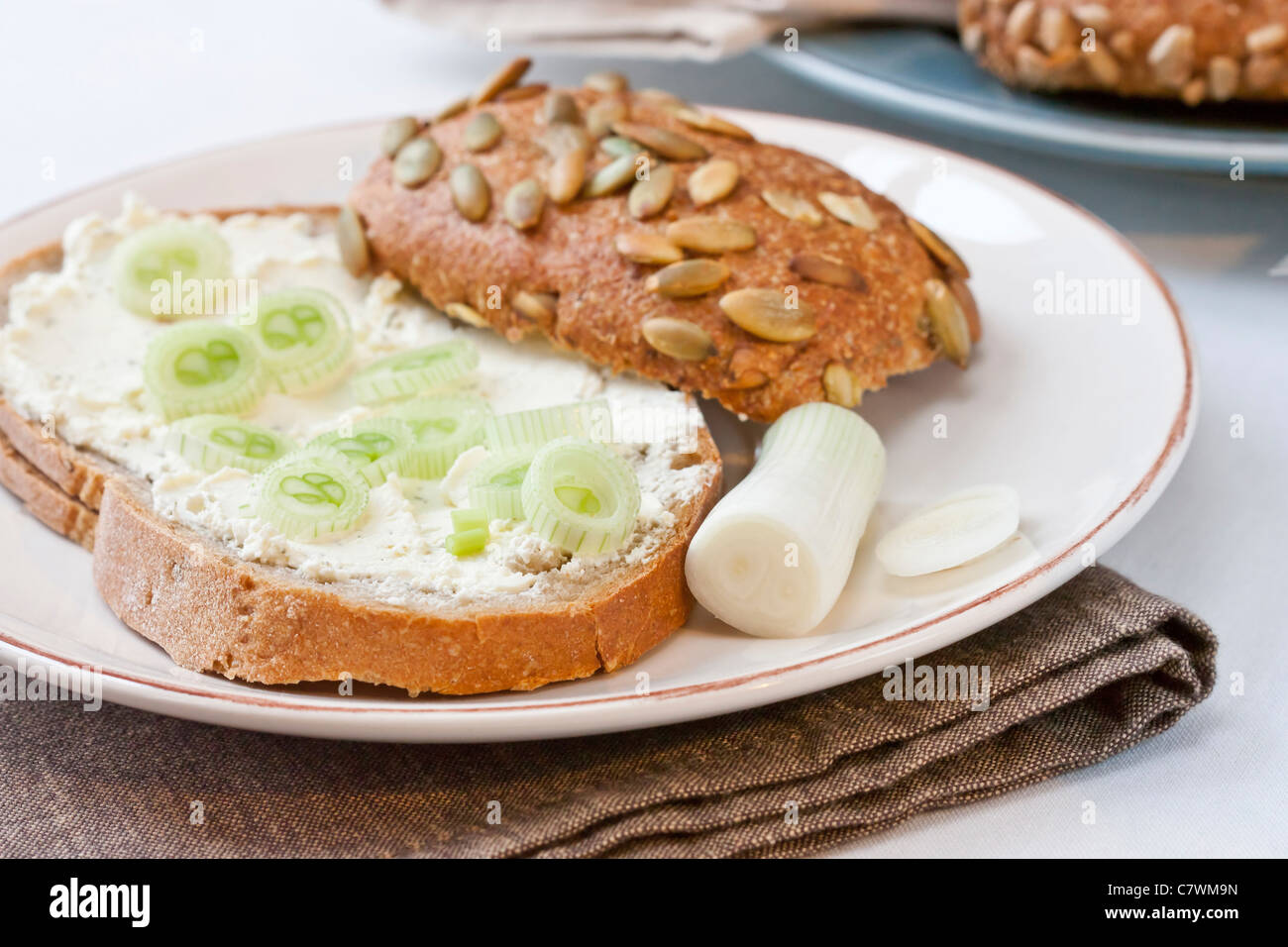 Frühstück mit Brot, Frischkäse und Frühlingszwiebeln. Stockfoto