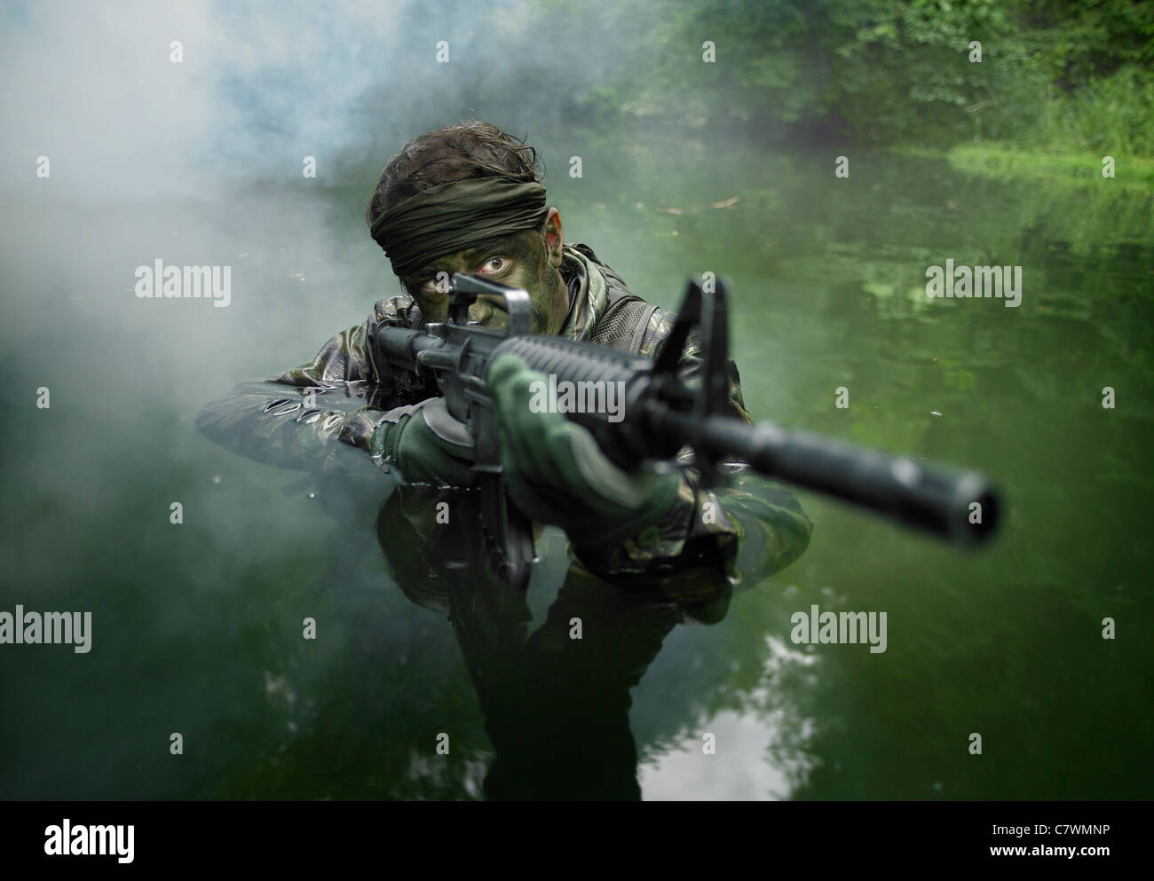 Spezielle Operationen Kräfte Soldat Transite das Wasser mit einem Sturmgewehr bewaffnet. Stockfoto