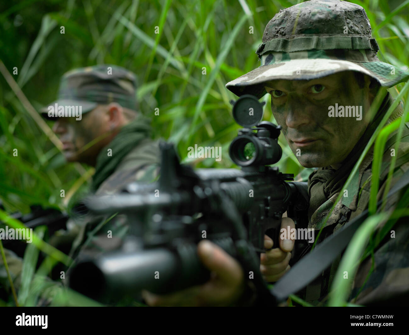 US Special Forces Soldaten patrouillieren durch hohe Gräser während des Kampfes. Stockfoto