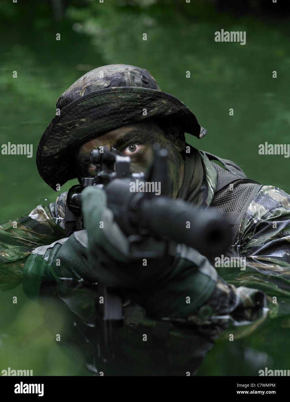 Spezielle Operationen Kräfte Soldat Transite das Wasser mit einem Sturmgewehr bewaffnet. Stockfoto