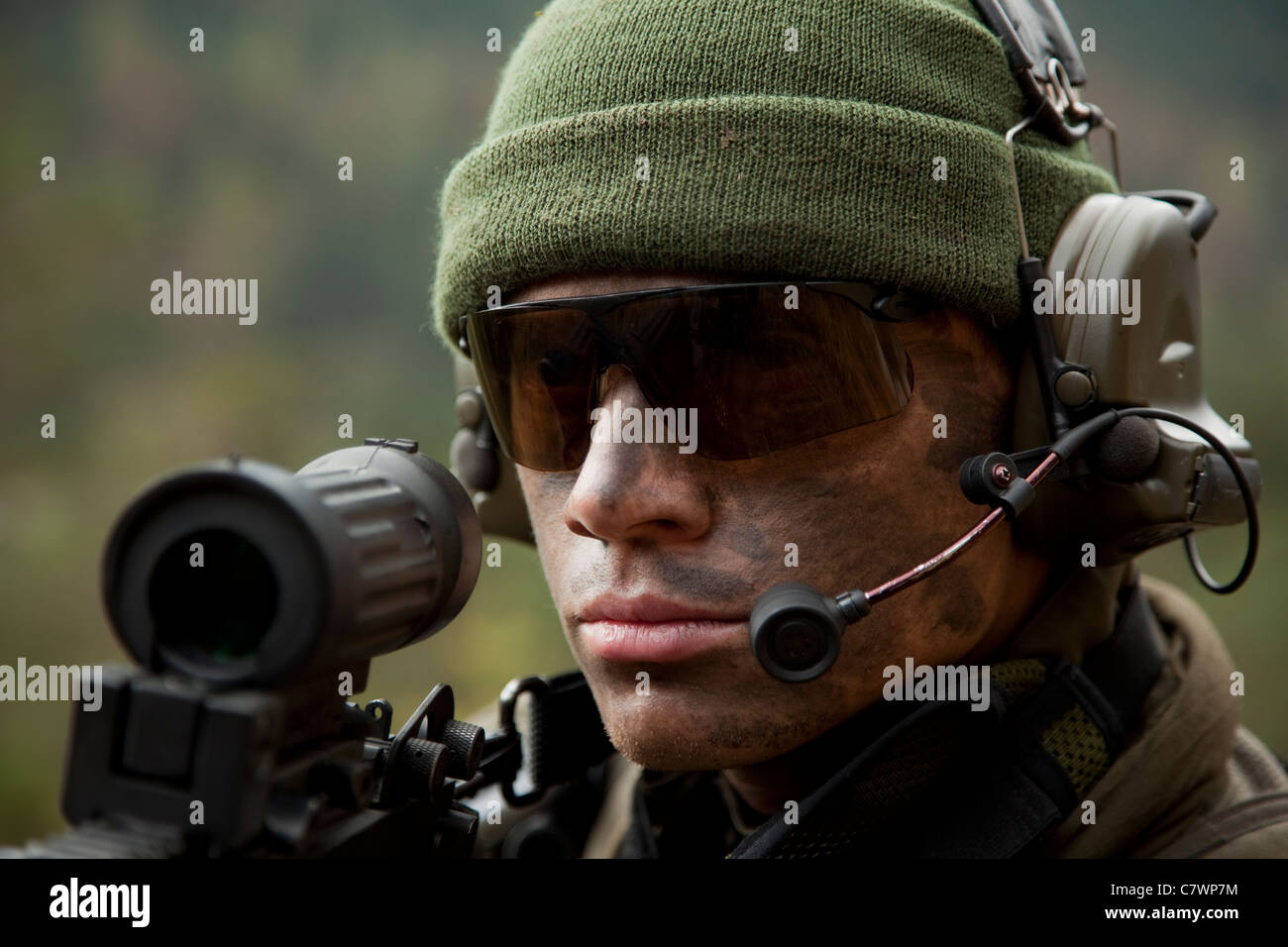 US Special Forces Soldaten bleibt Warnung während des Tragens ein Funk-Kopfhörer während des Kampfes. Stockfoto