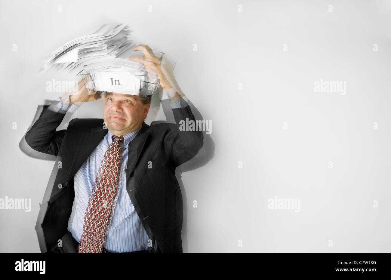 Business-Mann stark fließenden-Box Papiere auf dem Kopf balancieren. Stockfoto