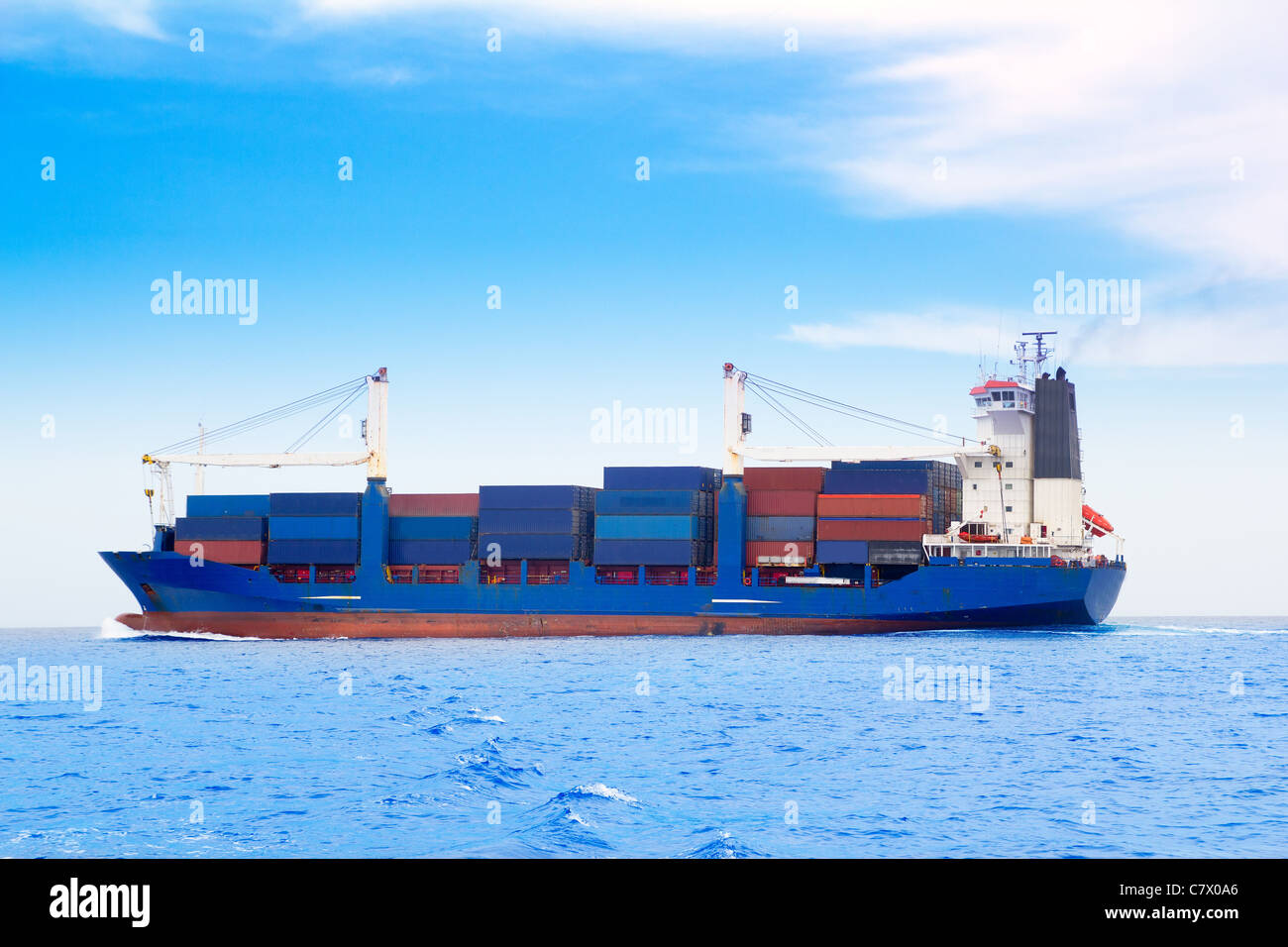 Frachtschiff mit Containern im tiefblauen Meer Stockfoto