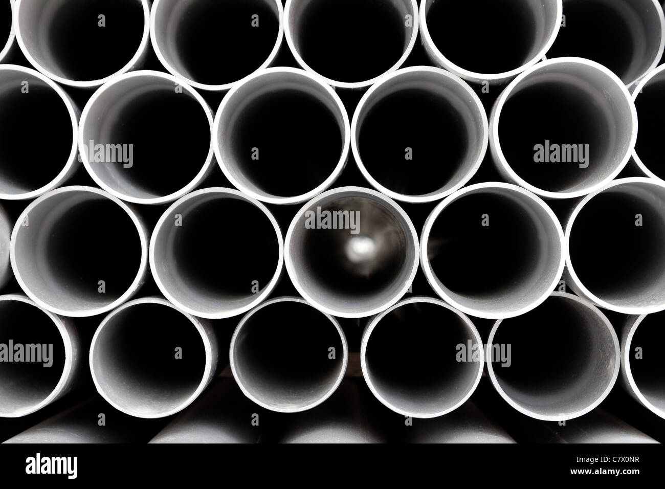 grauer PVC-Rohre Kunststoffrohre in Zeilen Muster gestapelt Stockfoto