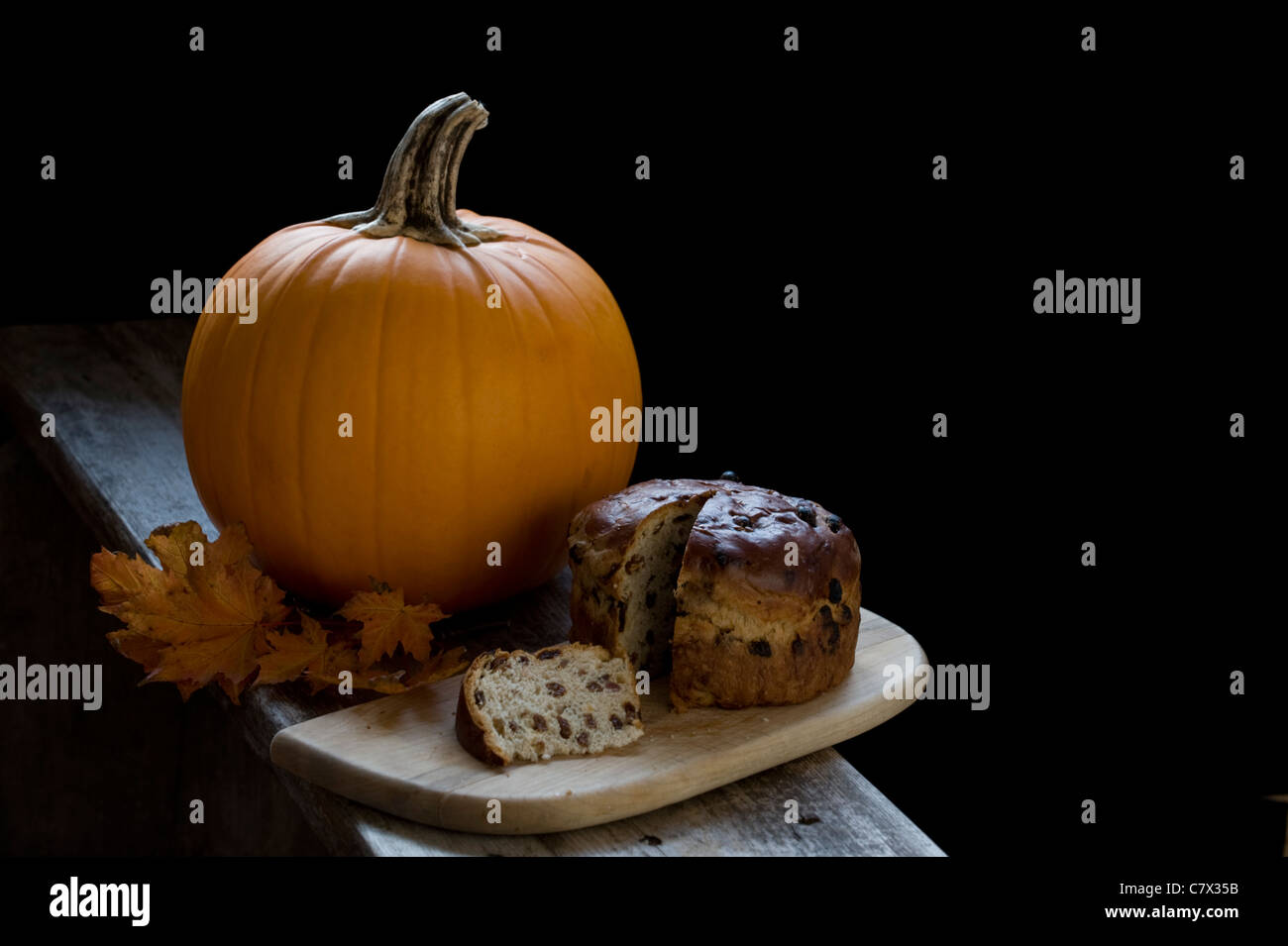 Kürbis mit Obst Brot bracken und Herbstlaub auf Holz mit schwarzem Hintergrund redaktionellen Raum auf der rechten Seite bild Landschaft Stockfoto