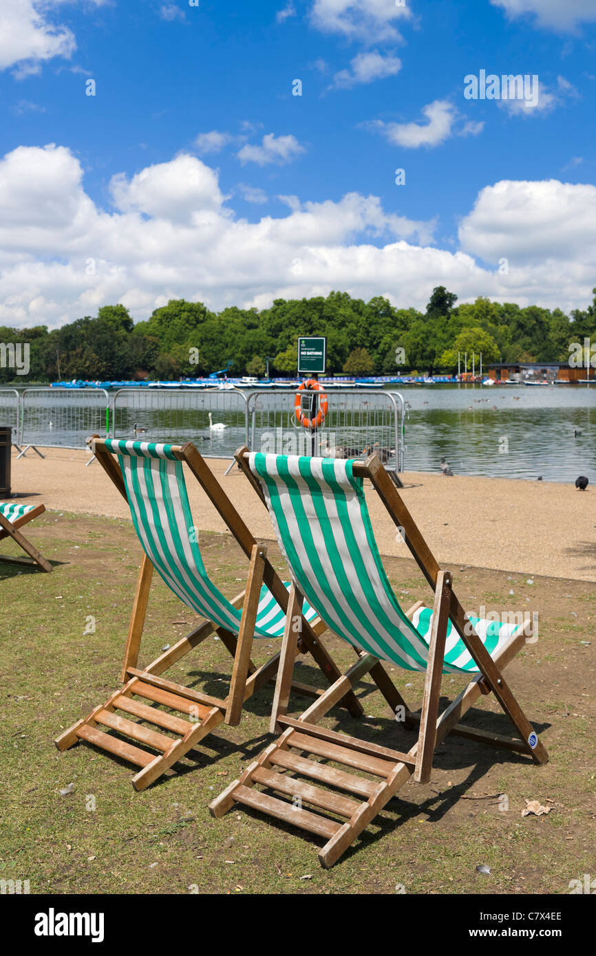 Liegestühle mit der Serpentine in Hyde Park, London, England, UK Stockfoto