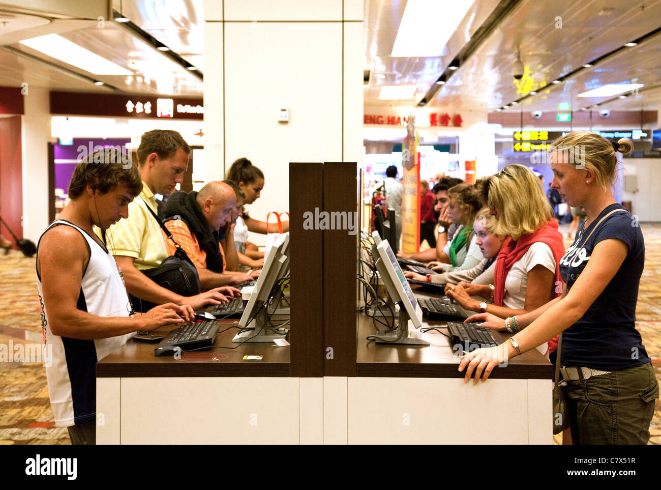 Fluggäste, die mit dem Computer in der Abflughalle, Changi Airport Singapur Asien Stockfoto