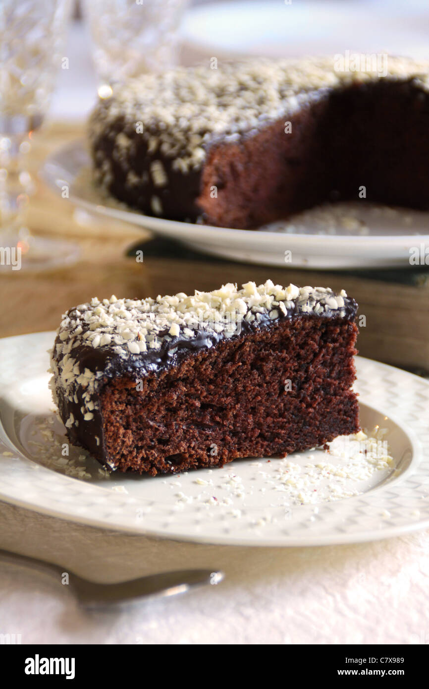 Ein Stück dunkle Schokolade Kuchen bestäubt mit geriebener weißer Schokolade Stockfoto