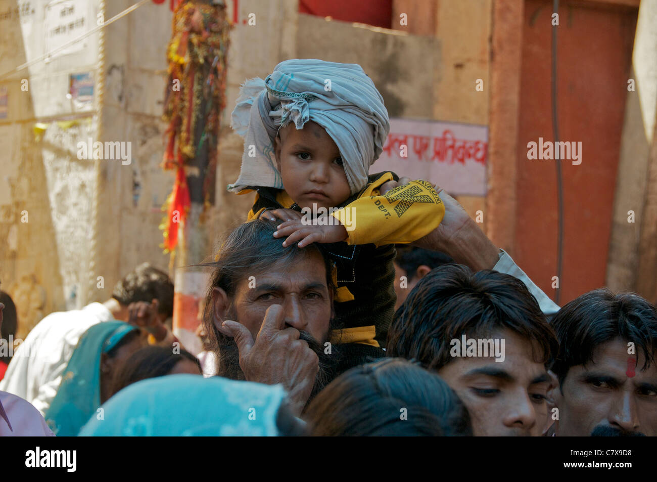 Kleiner Junge auf Väter Schultern Queueing, Tempel bei Kaila Devi Rajasthan Indien zu besuchen Stockfoto