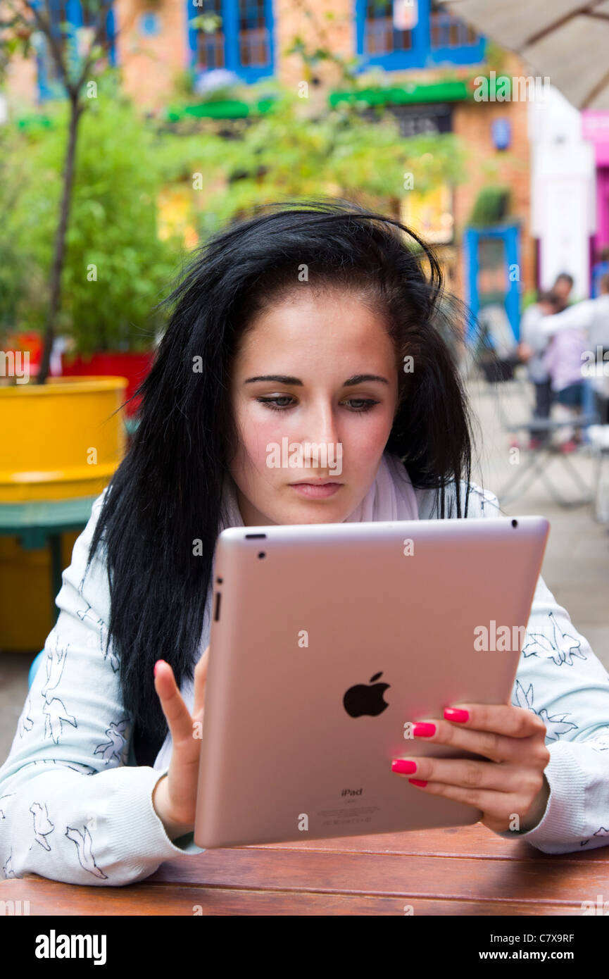Teenager mit Apple iPad 2 Tablet Computer im Freien, London, England, UK Stockfoto