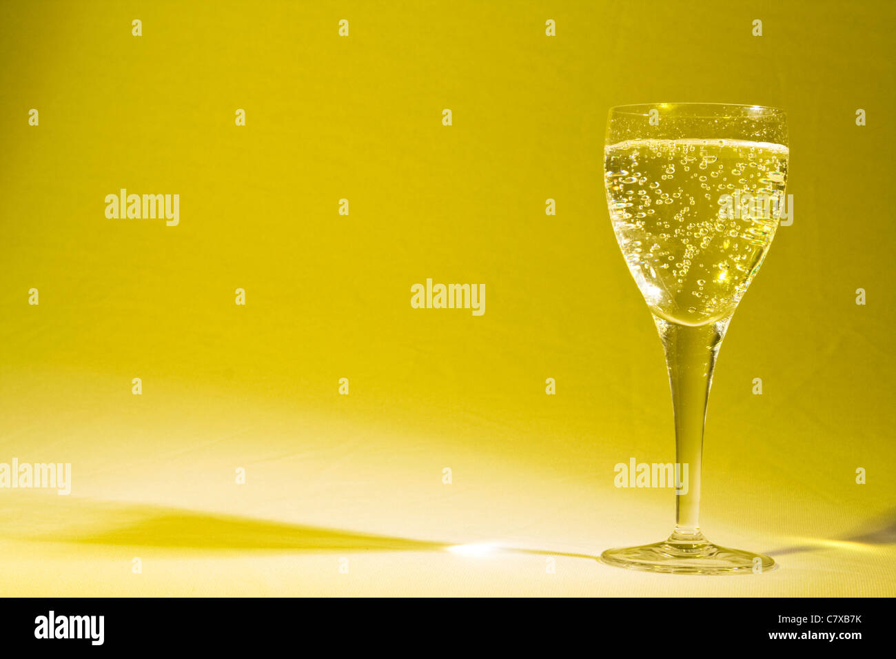 Champagner im Glas, gelber Hintergrund Stockfoto