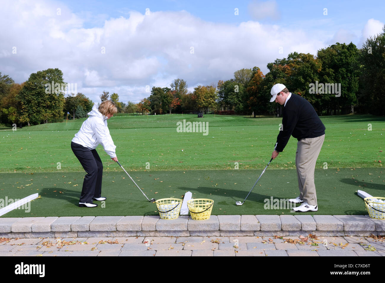 Zwei Golfer unter Adressposition auf einer driving Range. Stockfoto