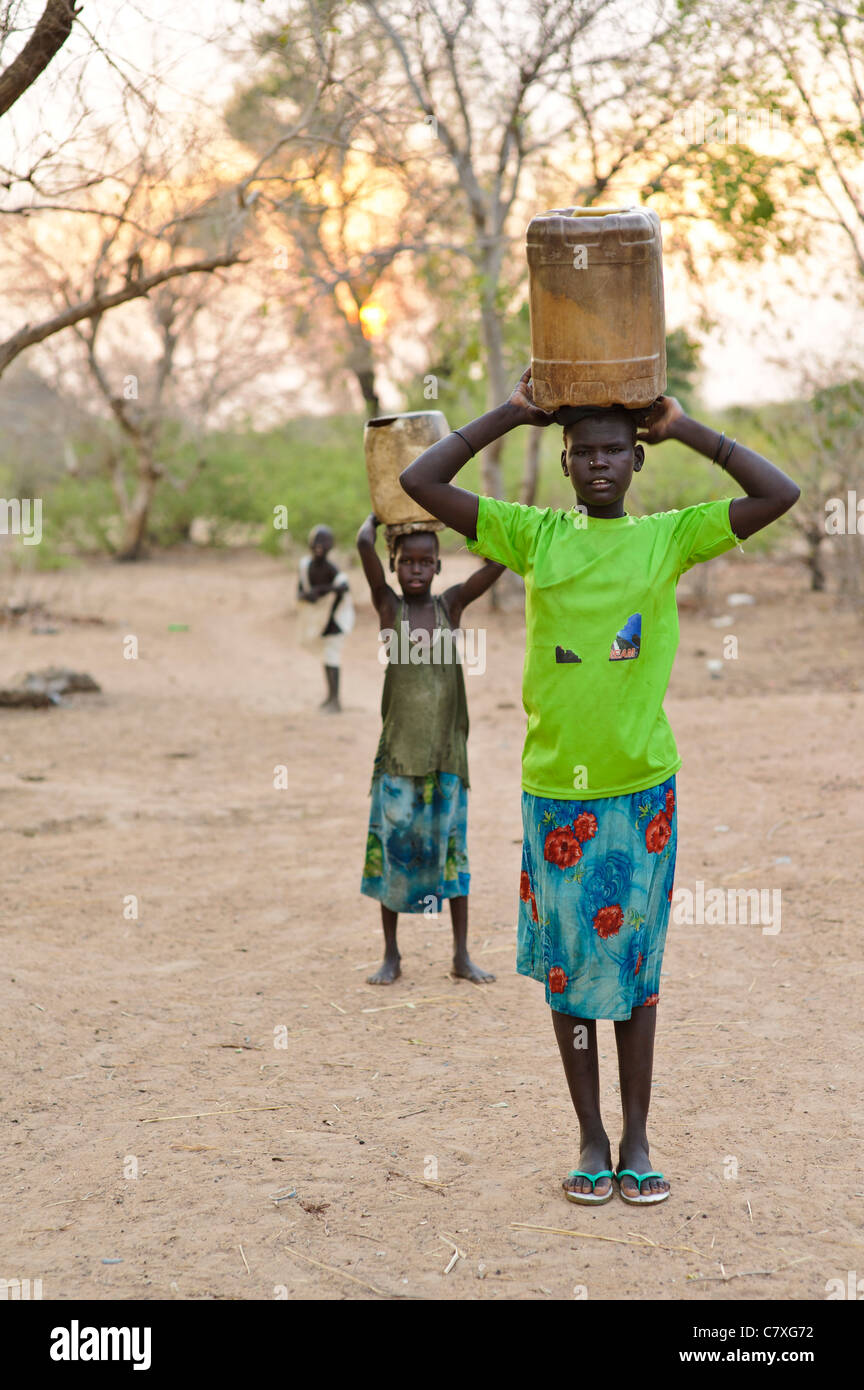 Junge Mädchen tragen von Wasser zurück aus dem Bohrloch, Luonyaker, Bahr El Ghazal, Süd-Sudan. Stockfoto