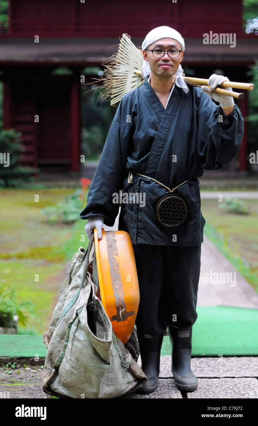Zen-buddhistischen Mönch auf Arbeit - Reinigung oder Gartenarbeit - Aufgaben im Tempelgelände, traditionellen Roben tragen. Stockfoto
