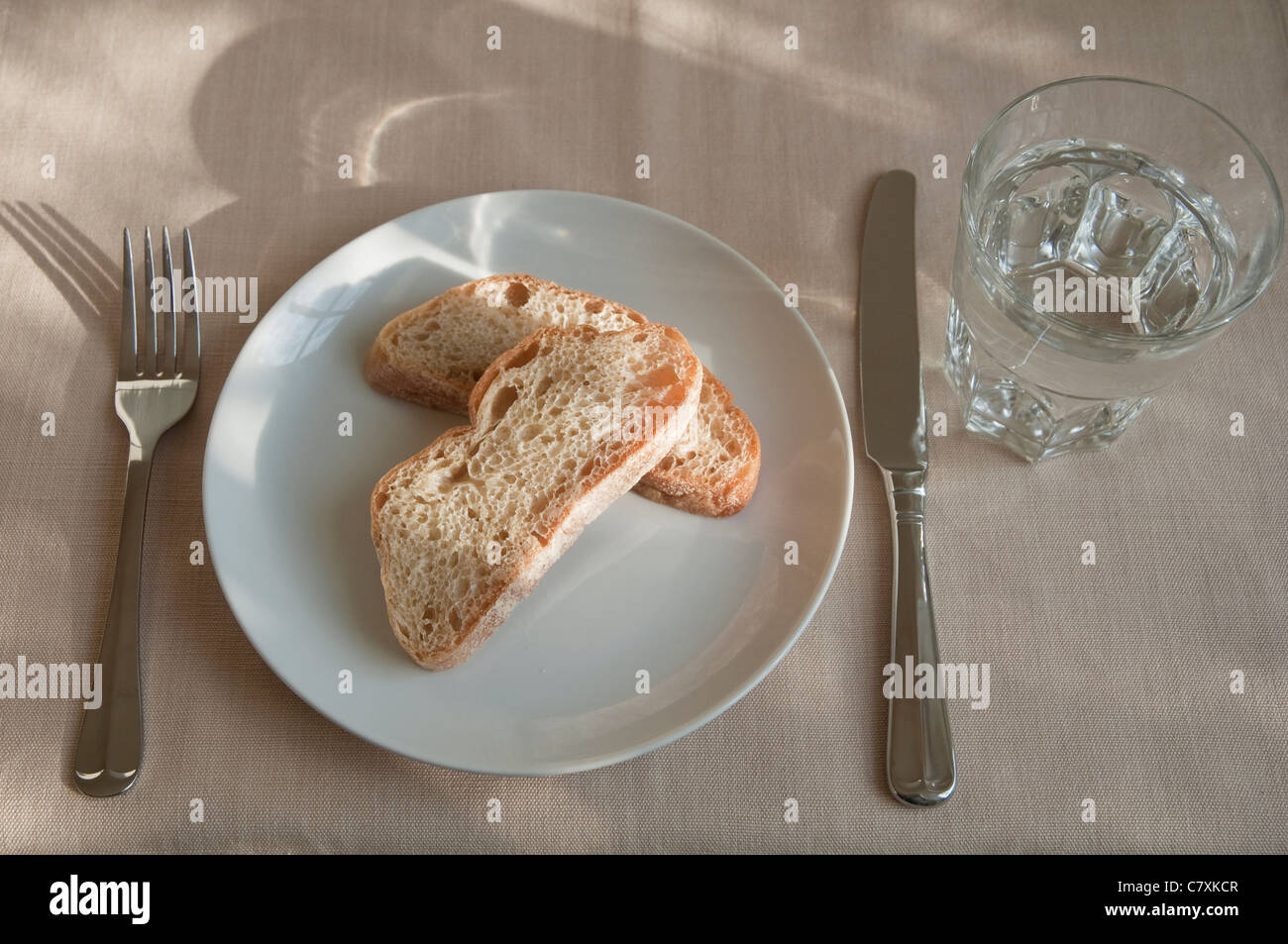 Brot und Wasser.  Eine sparsame Mahlzeit für eine Diät oder versuchen zu sparen - mit einem Glas Wasser mit zwei Scheiben Brot. Stockfoto