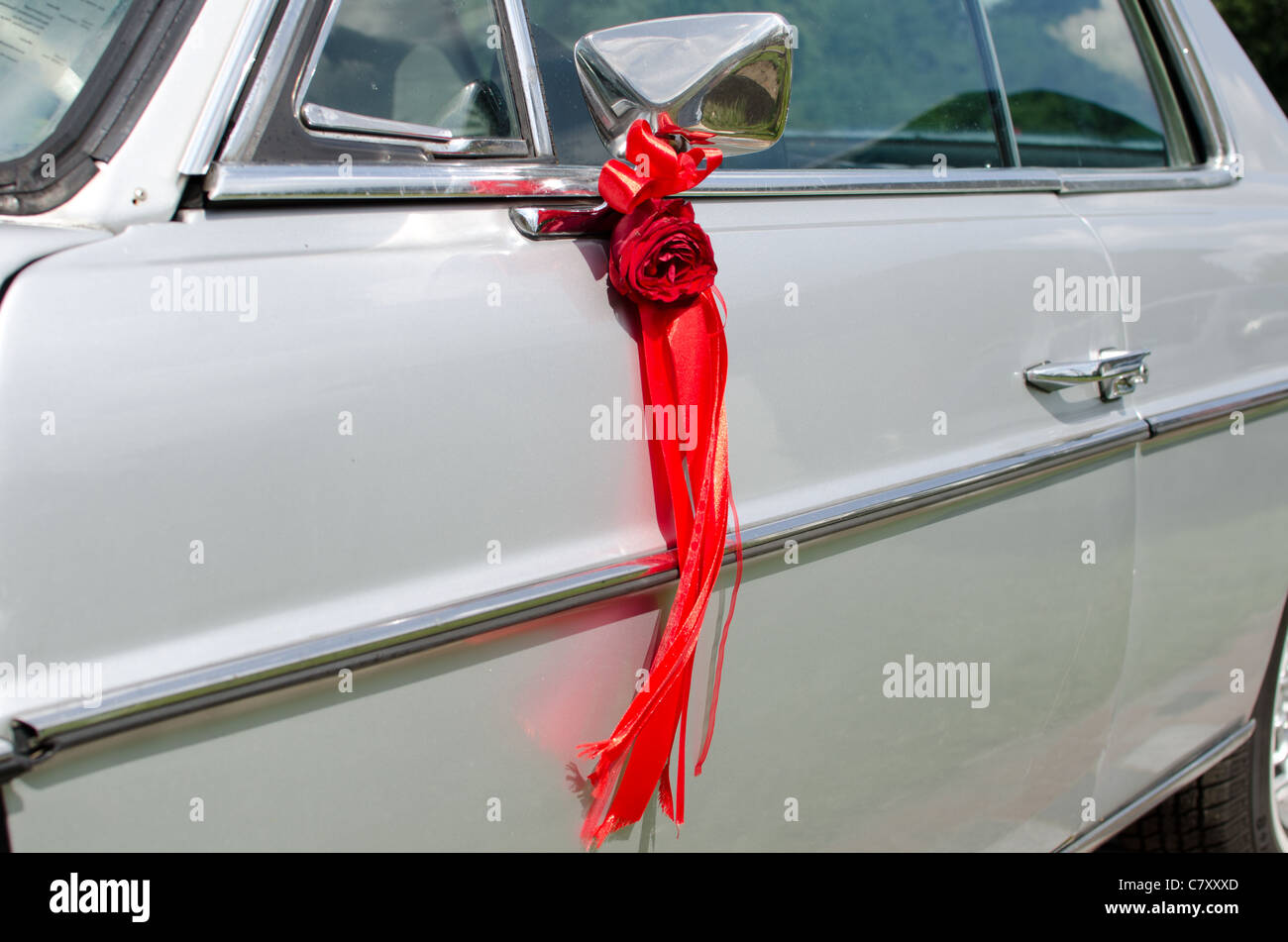 Rote Rose mit einer Band Dekoration auf einem Autospiegel Stockfotografie -  Alamy