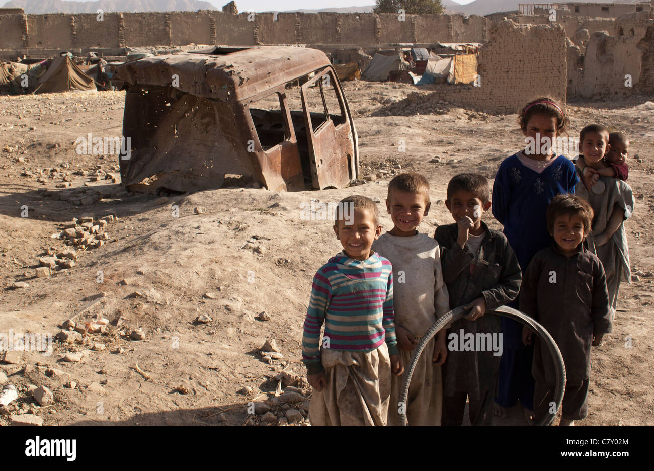 Eine Gruppe von intern vertriebenen Flüchtlingskindern auf einem offenen Grundstück in Kabul, Afghanistan. Afghanistan steht vor einer der akutesten Binnenvertreibungskrisen der Welt, da es unter langwierigen Konflikten, andauernder Unsicherheit und Naturgefahren wie Dürren, Überschwemmungen, Stürmen und Erdbeben leidet. Die Flucht ist für viele Afghanen zu einer vertrauten Überlebensstrategie geworden und in einigen Fällen ein unvermeidlicher Teil des Lebens für zwei Generationen. Noch komplizierter wird die Situation durch weitverbreitete Arbeitslosigkeit, Armut, Landlosigkeit und fehlende Grundversorgung. Stockfoto