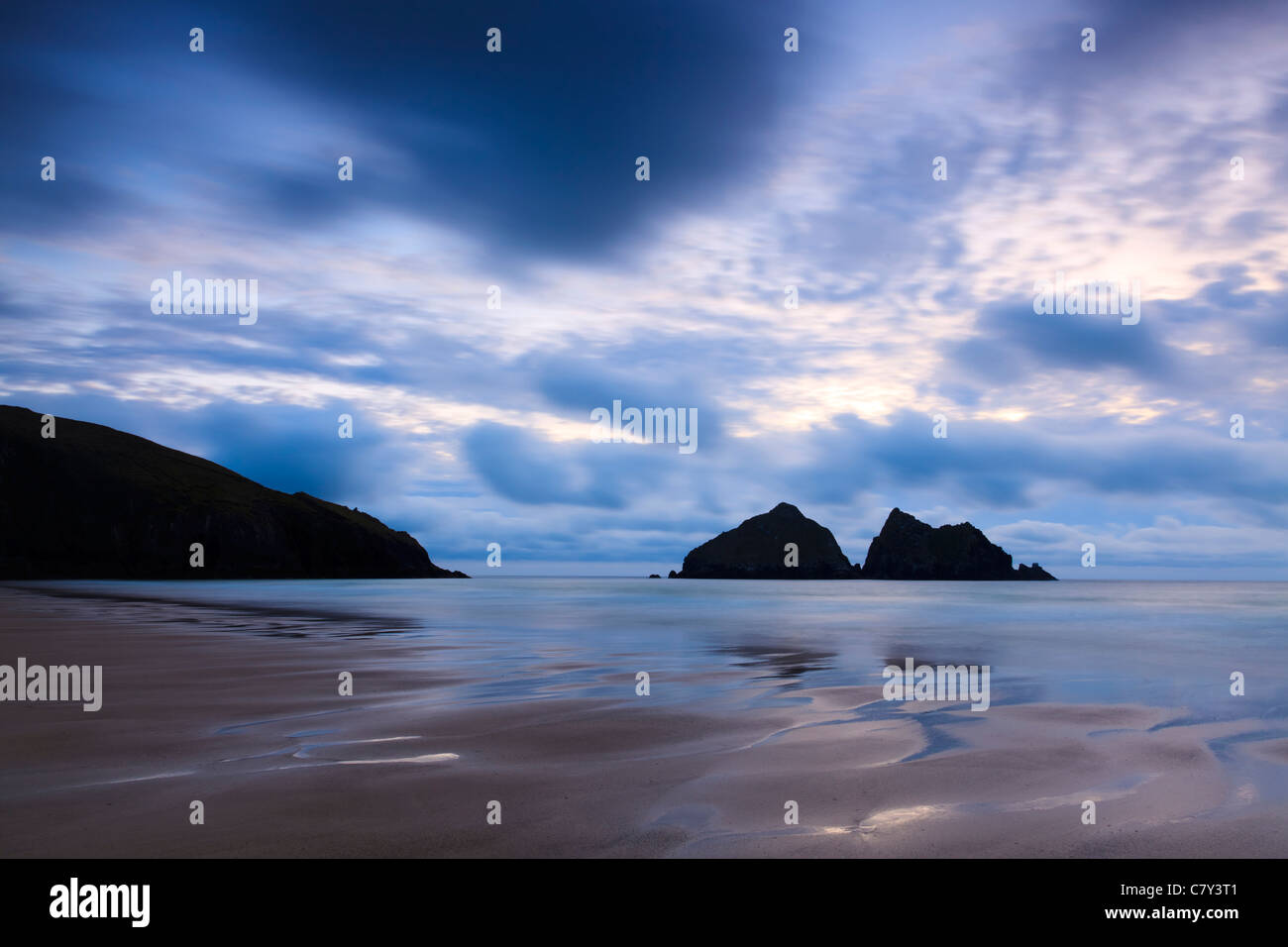 Stimmungsvolle Sonnenuntergang am Strand von Holywell Bay Cornwall England mit Carters Felsen in der Ferne. Stockfoto