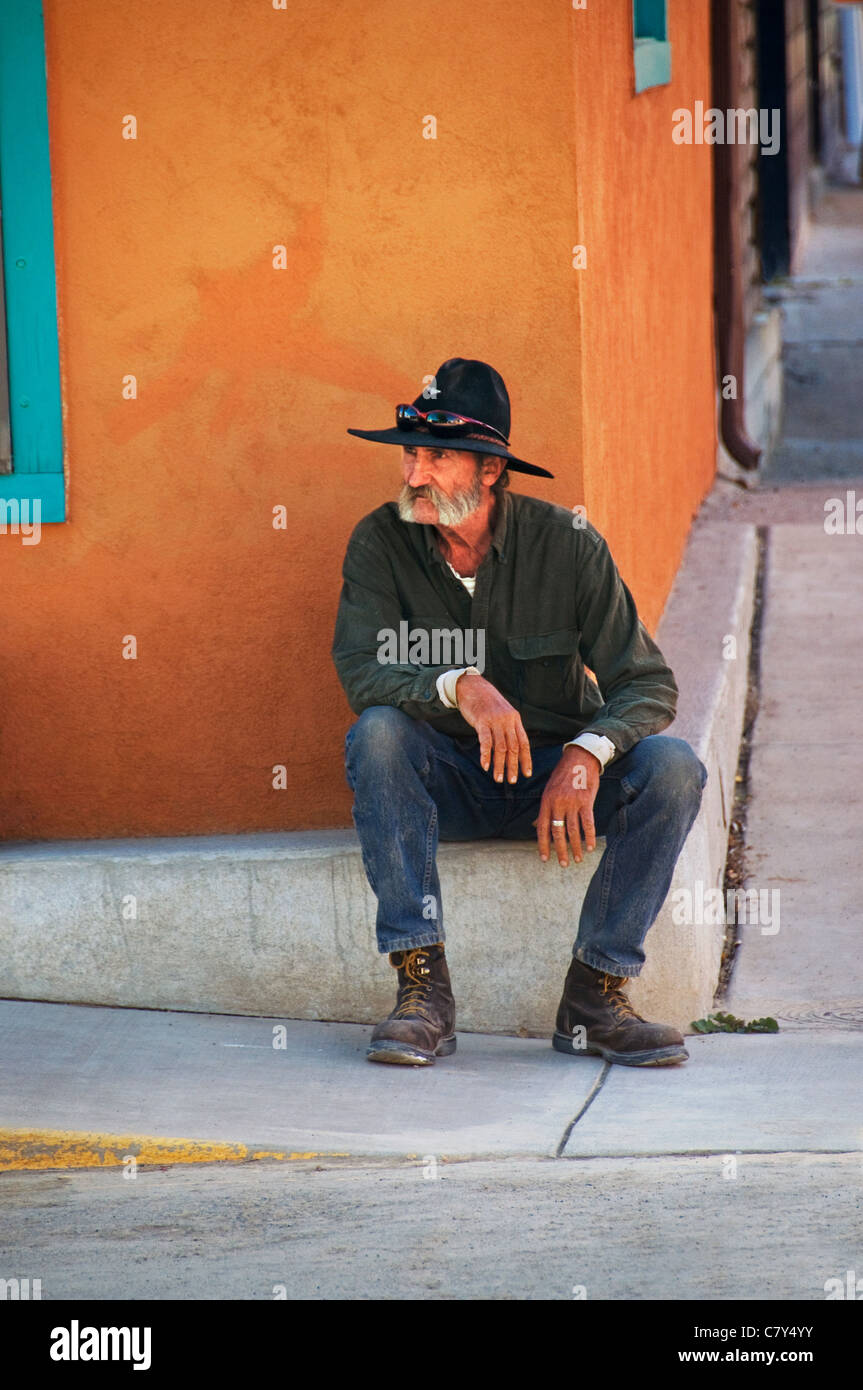 Cowboy sitzen Straßenecke Stockfoto