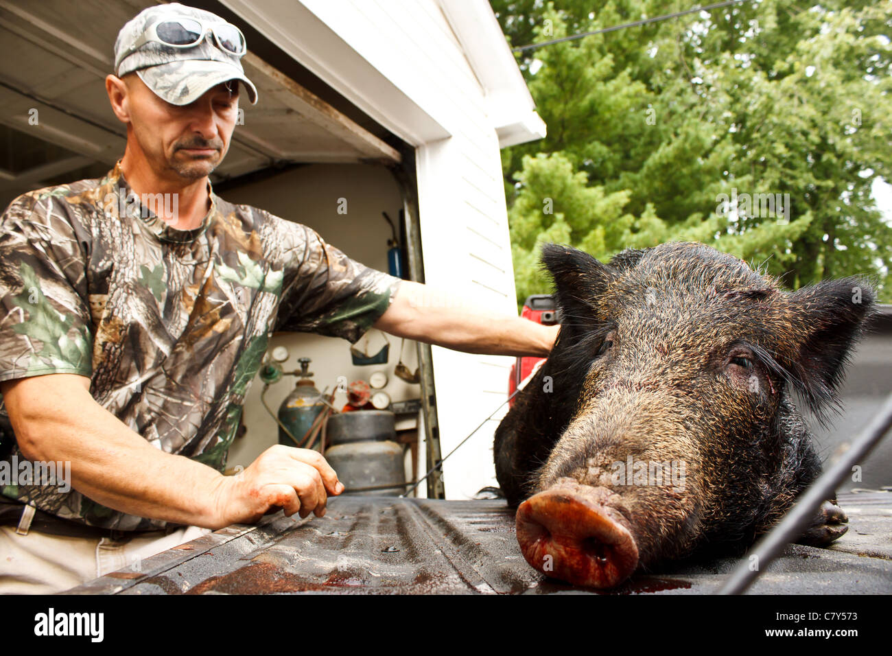 Jäger, die Augen zu verschließen, während neben Wildschwein getötet Stockfoto