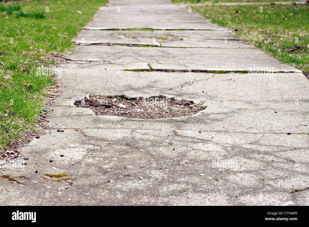 Gebrochene Gehweg mit Schlagloch reparaturbedürftig Stockfoto