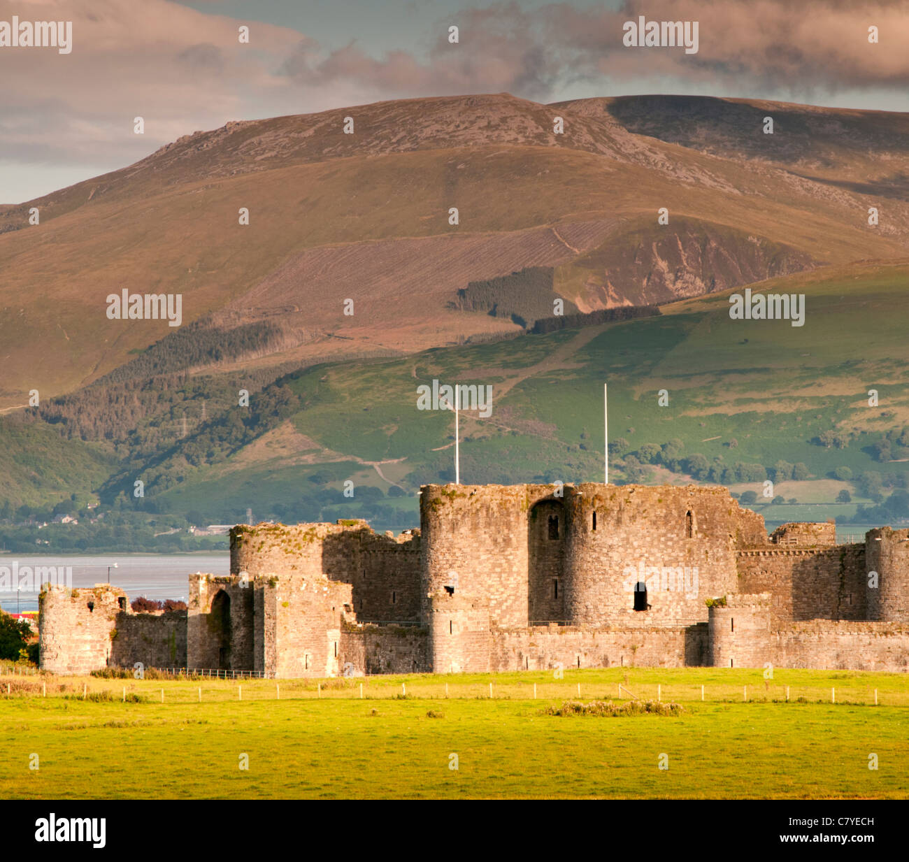 Beaumaris Castle unterstützt von Snowdonia, Beaumaris, Anglesey, North Wales, UK Stockfoto