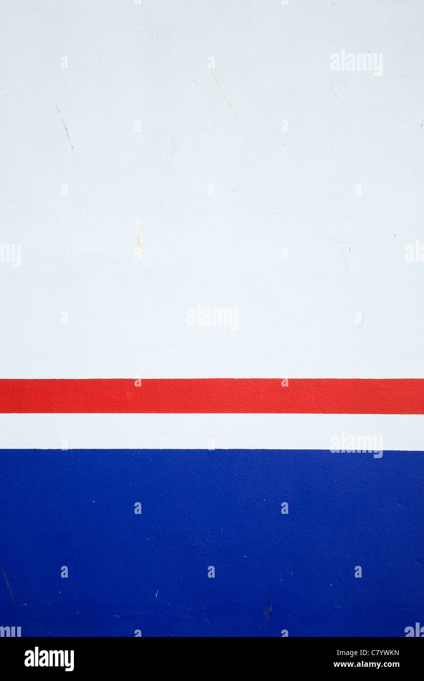 Rote und blaue Streifen auf einer weißen Wand. Stockfoto