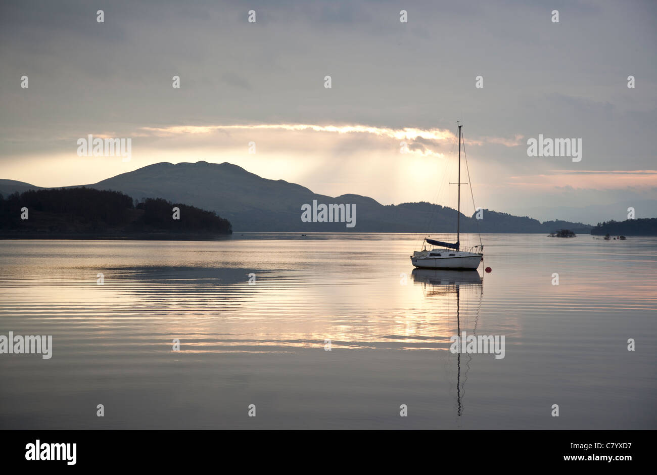 Eine Yacht ankern in Loch Lomond, Schottland als die Sonne aufgeht. Stockfoto