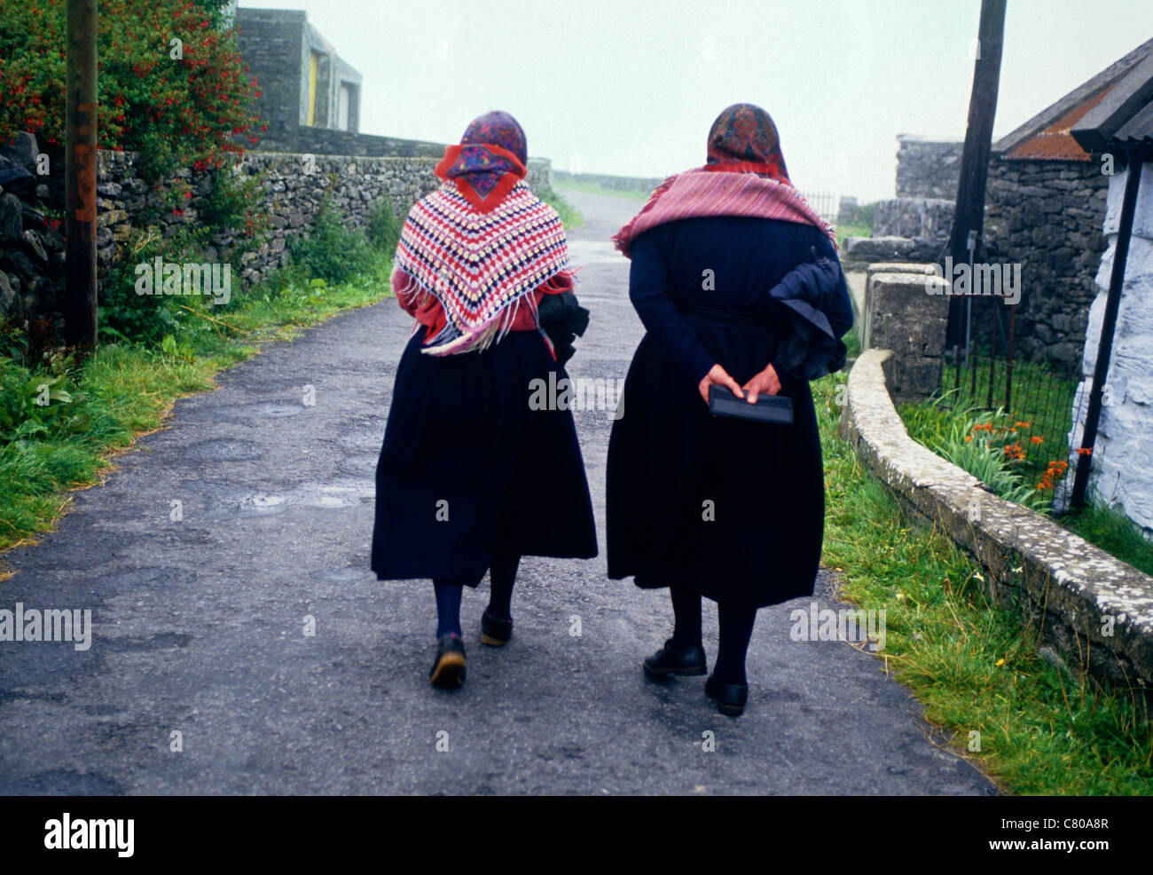 Zwei Frauen tragen traditionelle Kleidung Fuß nach Hause vom täglichen Messe auf eines der Aran-Inseln in Co Galway Irland Stockfoto