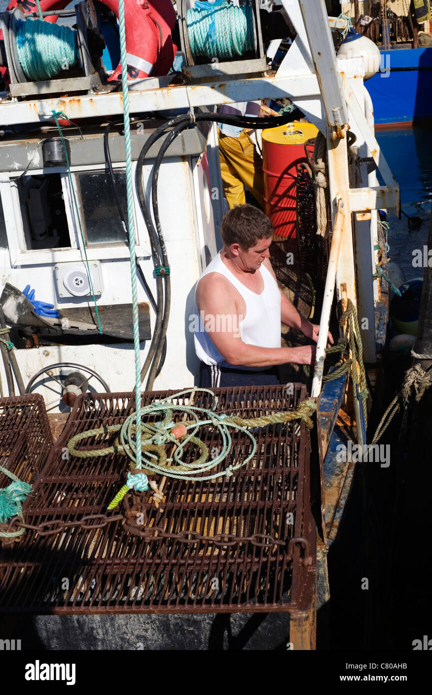 Tiefsee-Angler auf seinem Boot im Hafen arbeiten Stockfoto