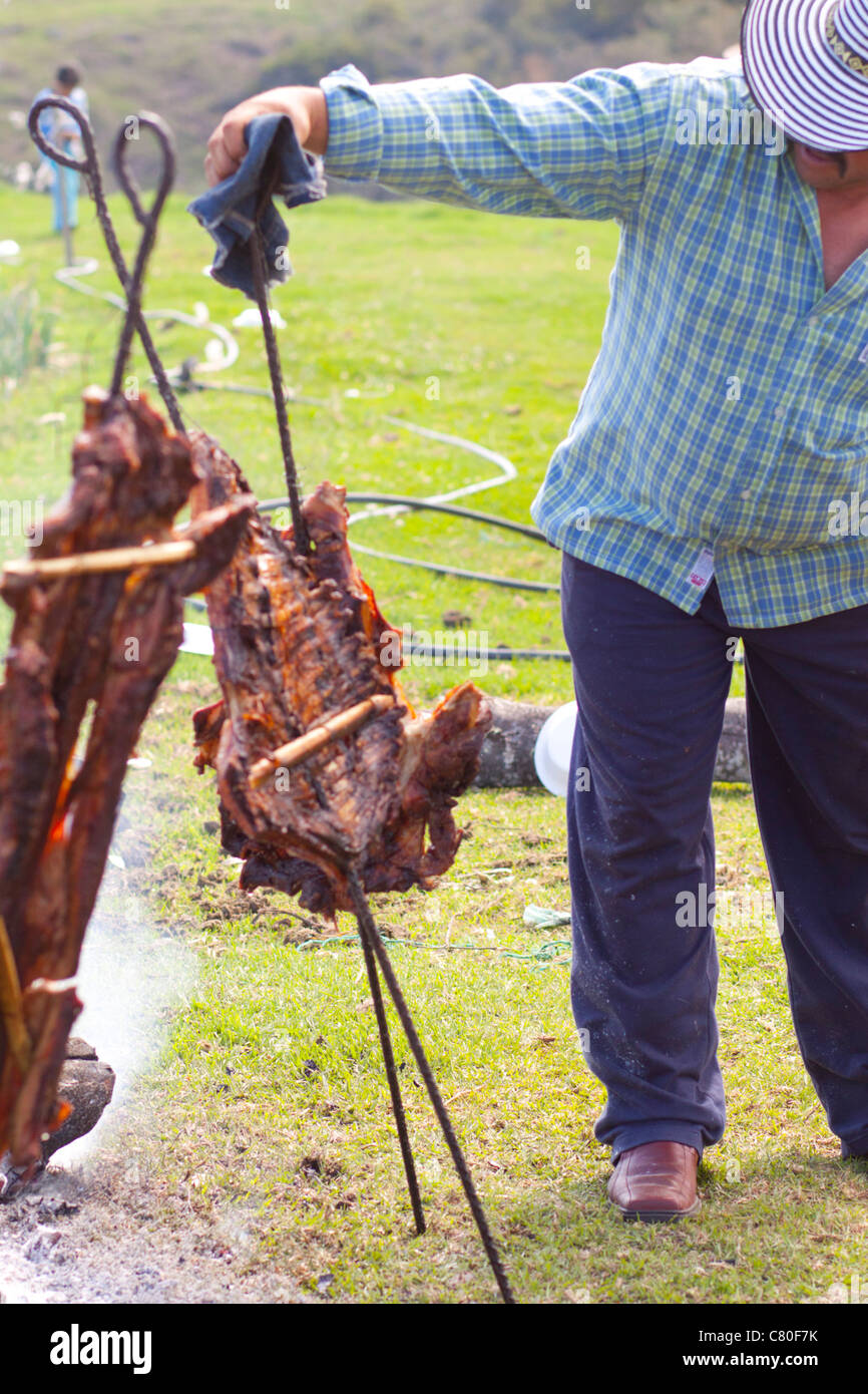 Mann Braten Fleisch Kuh auf einem improvisierten Feuer im Freien. Toca, Boyacá, Kolumbien, Südamerika Stockfoto