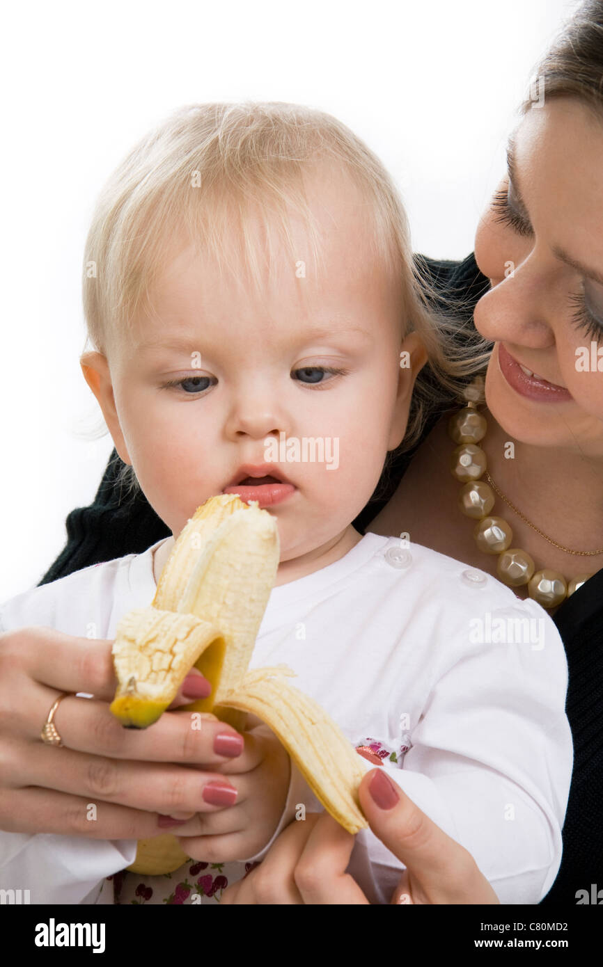 Mutter ernährt das Kind mit einer Banane. Stockfoto
