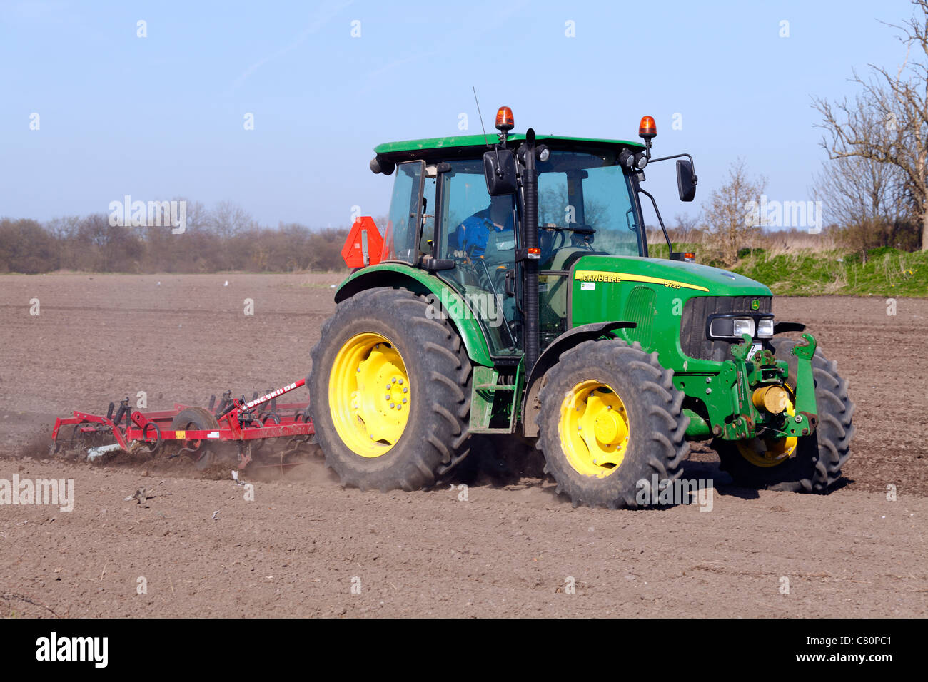 Traktor zu pflügen und Eggen des Bodens vor der Aussaat im Frühjahr auf Dragør auf der Insel Amager, in der Nähe von Kopenhagen, Dänemark Stockfoto