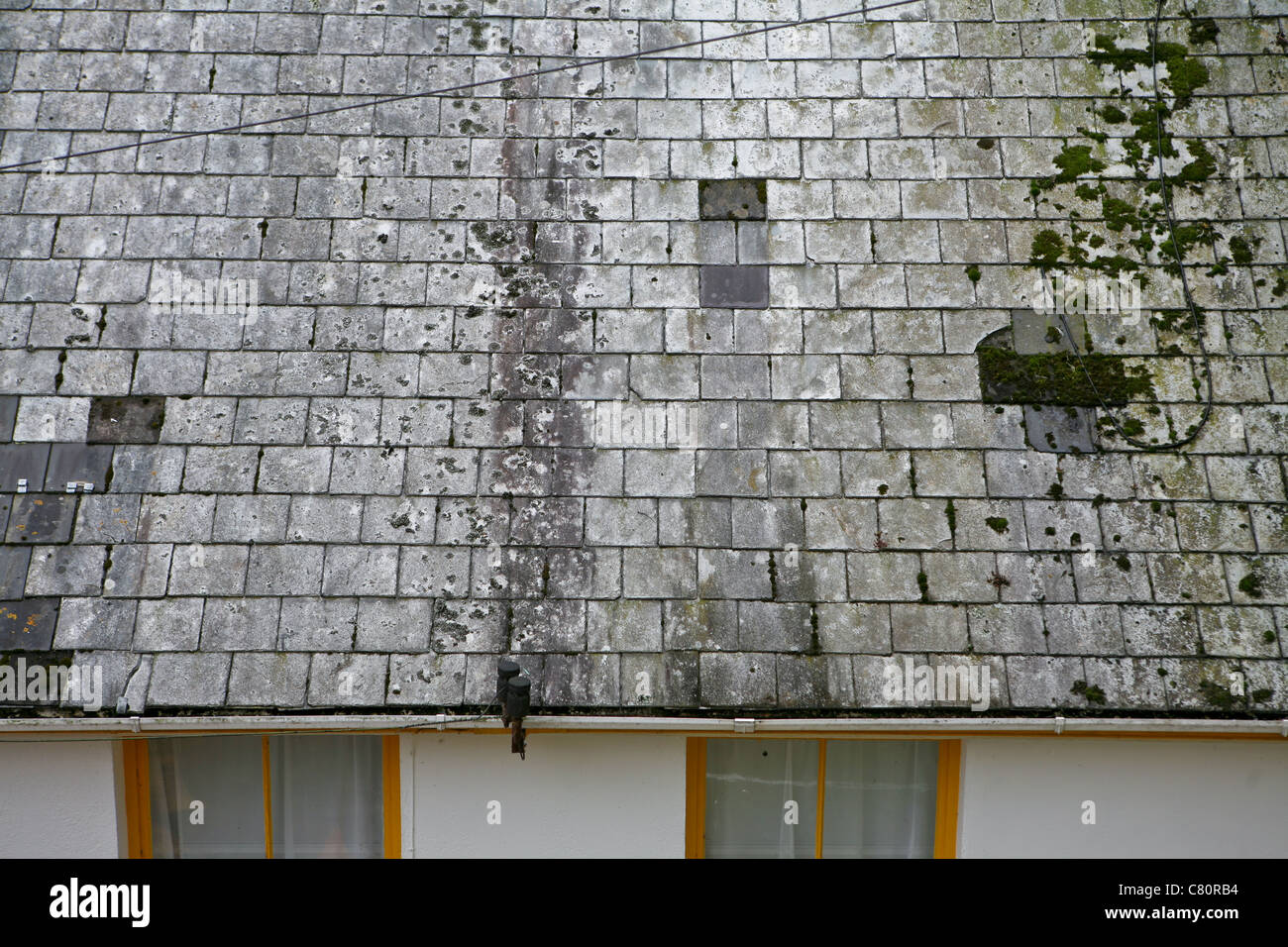 Alte verfärbte Schieferdachziegel auf einem Hausdach Stockfoto